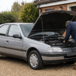 Prospective buyer inspecting a silver Peugeot 405 with its bonnet open