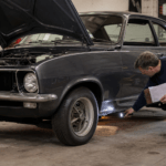 Enthusiast inspecting the sill of a classic project car before buying