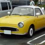 Topaz Mist Nissan Figaro front three-quarter view